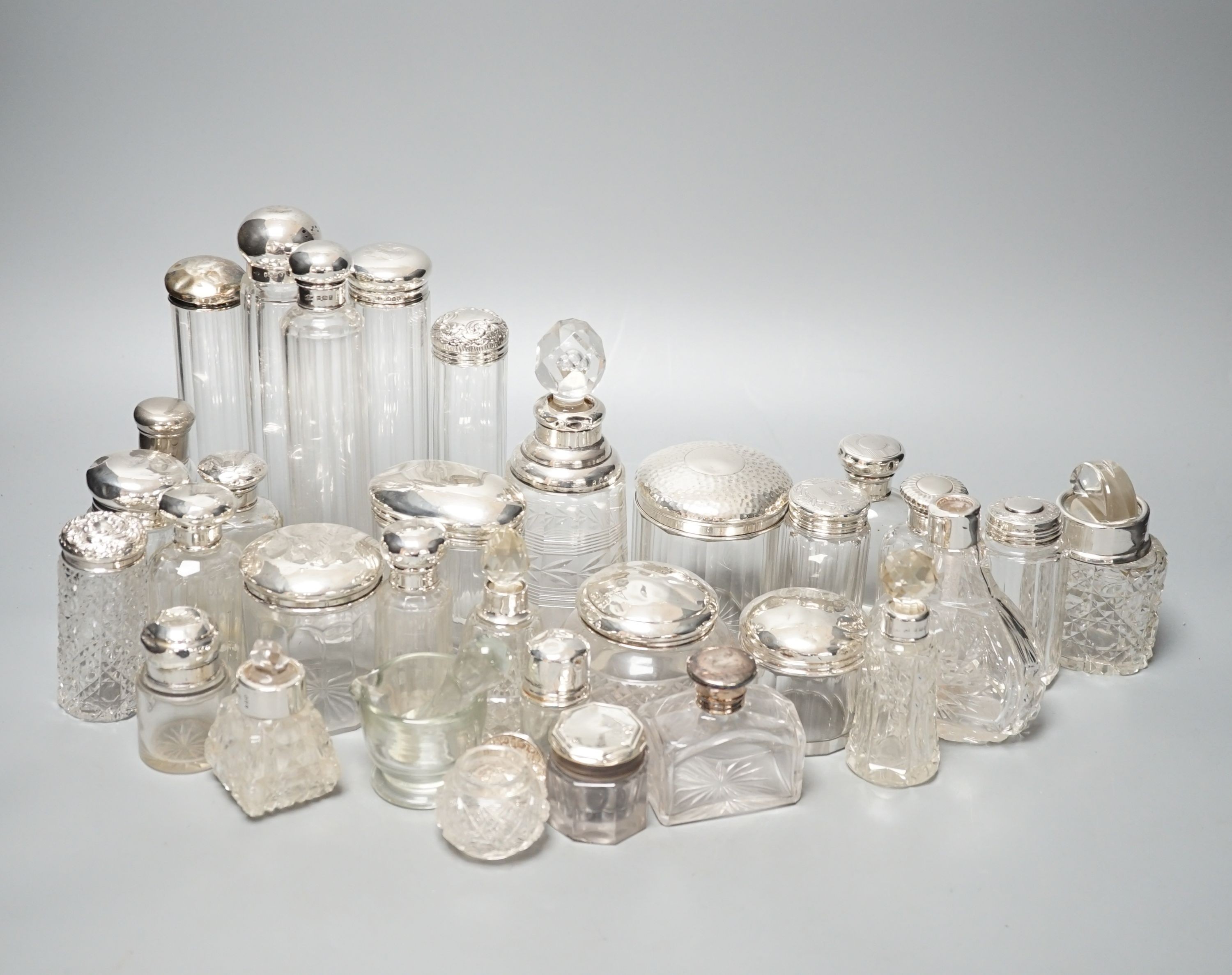 A collection of assorted mainly silver-capped scent bottles and toilet bottles.